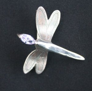 solid silver dragonfly brooch showing colour on the texure on the wings. Made ad part of the silver clay brooch course at www.lrsilverjewellery.co.uk